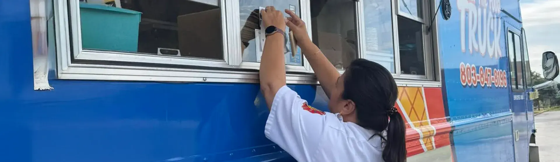 Fire Marshal Tammy Tolbert posts inspection sticker for local mobile food vendor.