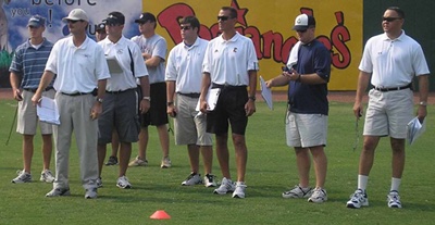 Coach watching prospects playing baseball