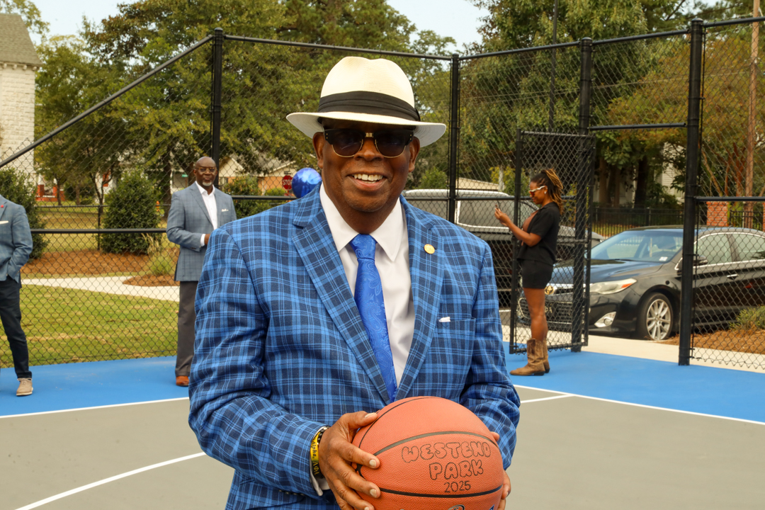 Mayor Pro Tem James Blassingame proudly shows off the ceremonial basketball commemorating the date.