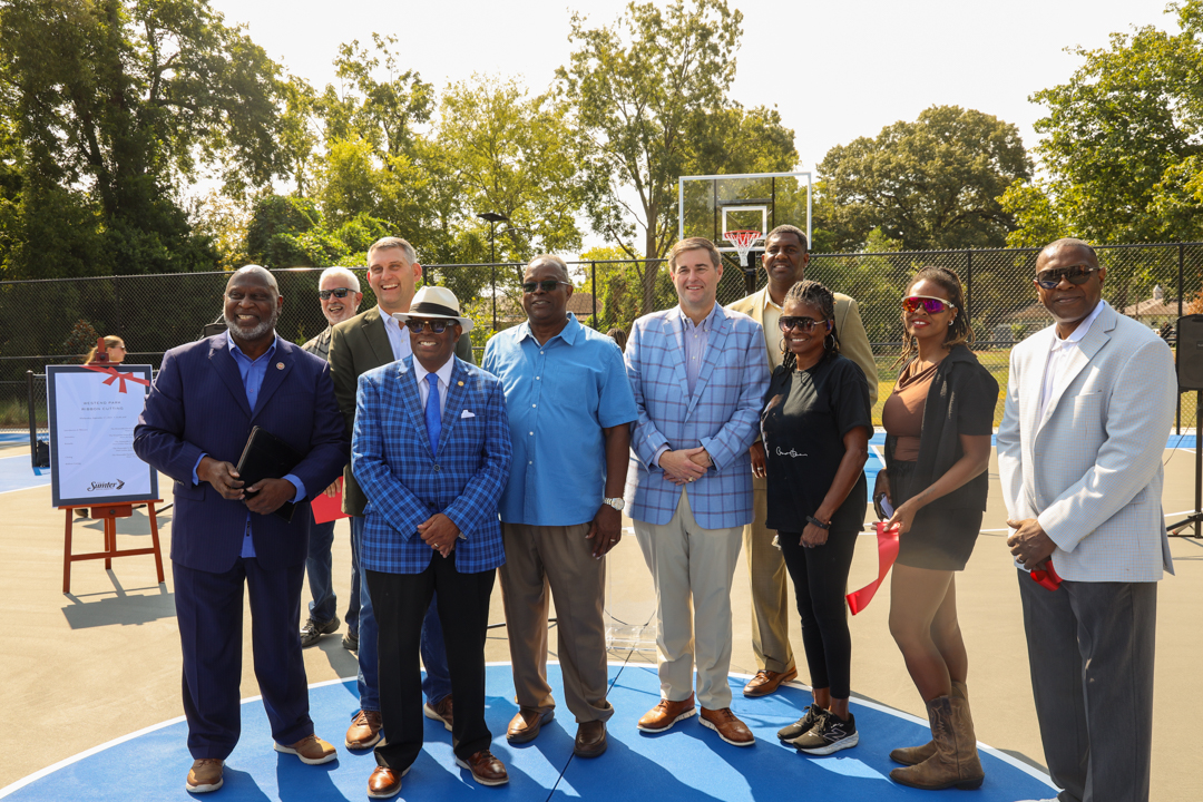 Oficcials and local neighborhood leaders pose on the new basketball courts at Westend Park