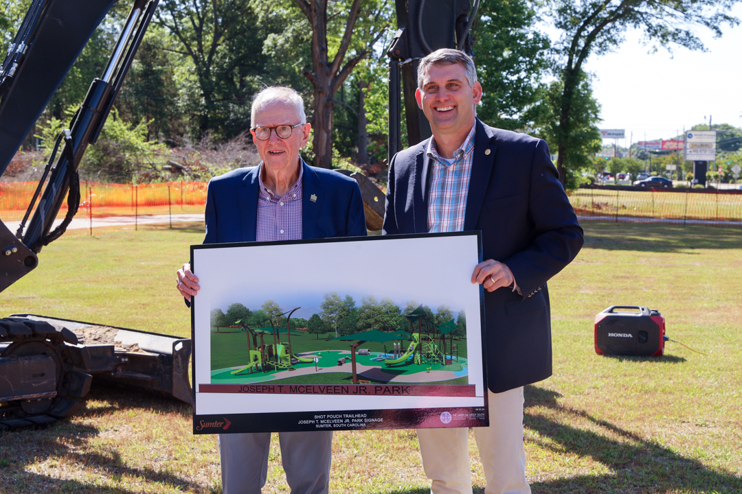 Mayor David Merchant and Former Mayor Joseph McElveen display the artistic rendition of the park to be constructed at the Broad Street Midway Trailhead.